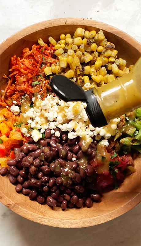 Sprinkling my go-to vinaigrette over the salad.