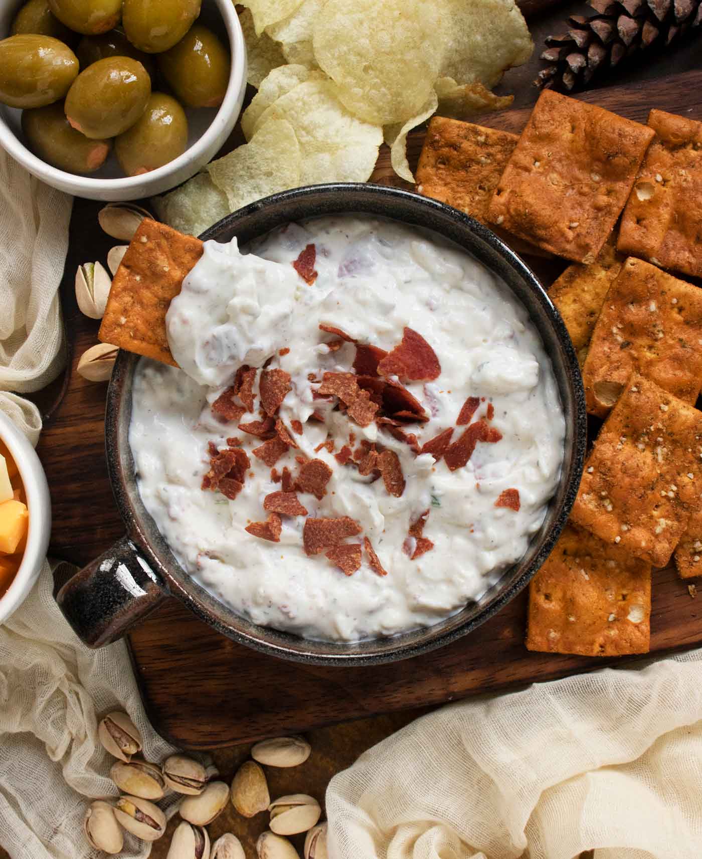 Close-up of a rectangular pretzel chip resting in the dip against the side of the bowl.
