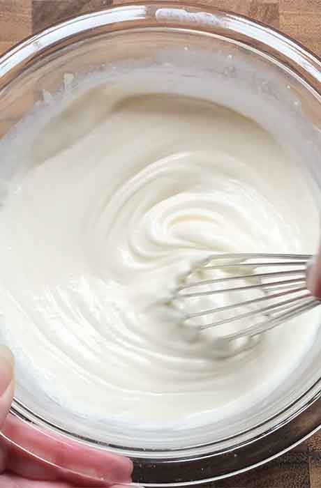 Whisking the mayo, sour cream, and cream in a small glass bowl until smooth and creamy.