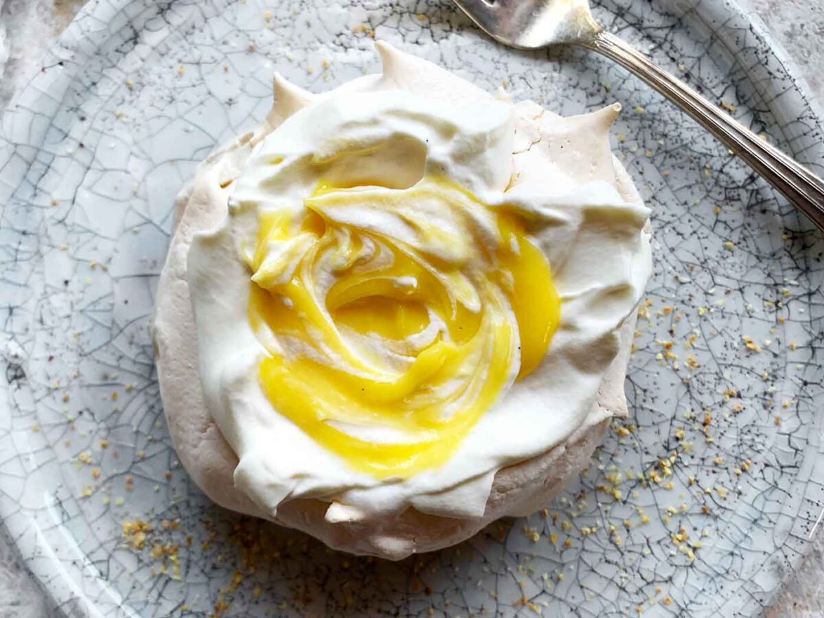 Close-up view of a Mini Pavlova with Tangerine Curd swirled in the center.
