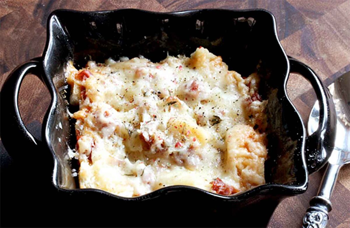 Tipsy Cheesy Bread in an individual serving black ramekin.