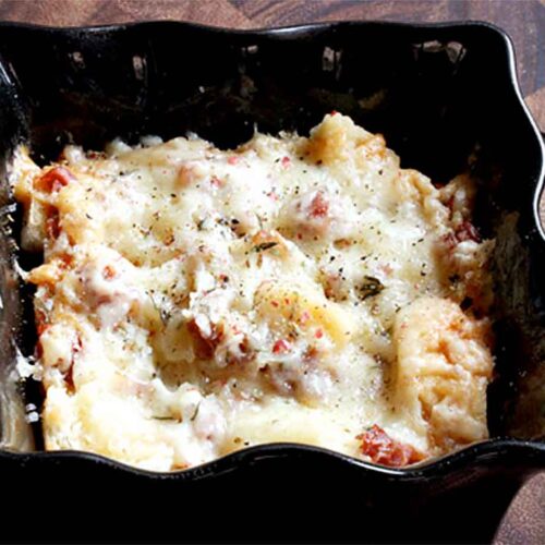 Tipsy Cheesy Bread in an individual serving black ramekin.