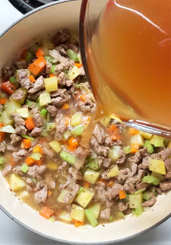 Pouring the broth into the pot.
