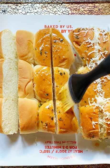 Brushing the rolls with the melted butter.