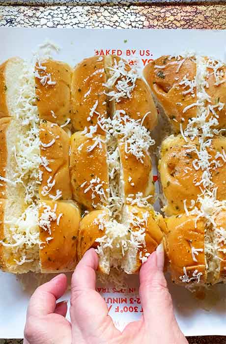 Stuffing the rolls with a bit of the shredded cheese.