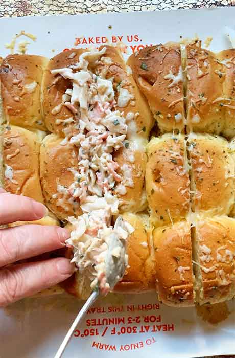 Spooning the crab salad into the toasted slider buns.