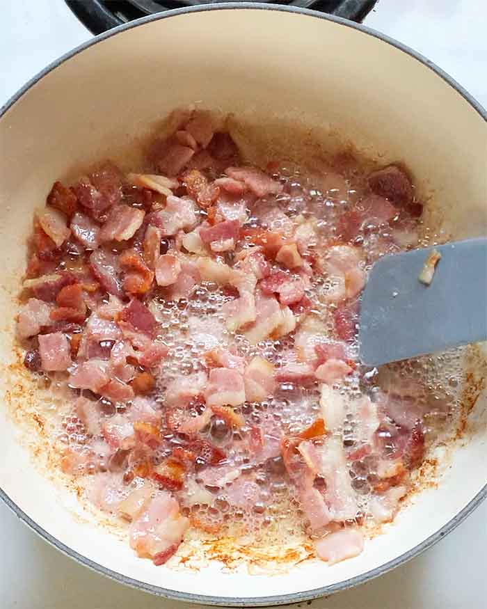 Cooking the bacon in the pot. Some fat has begun to render.