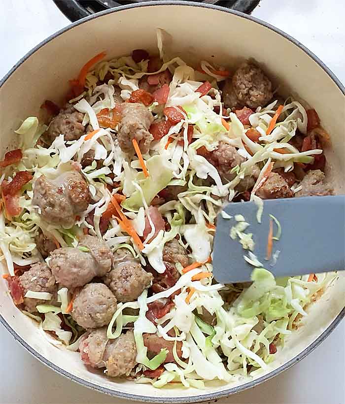 Adding the cabbage to the pot.