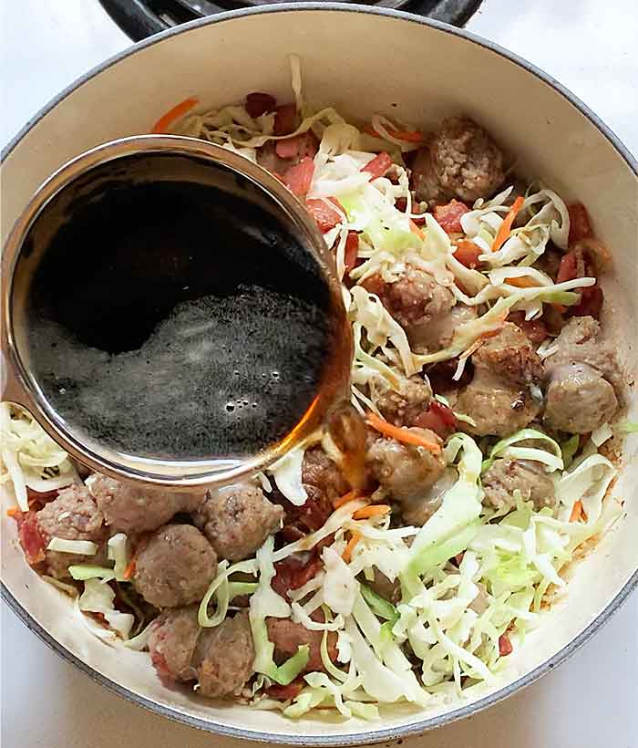 Pouring in the Guinness beer to build the foundational layer of flavor.