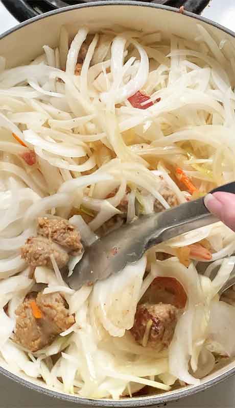 Adding the onions and gently folding them into the base ingredients.