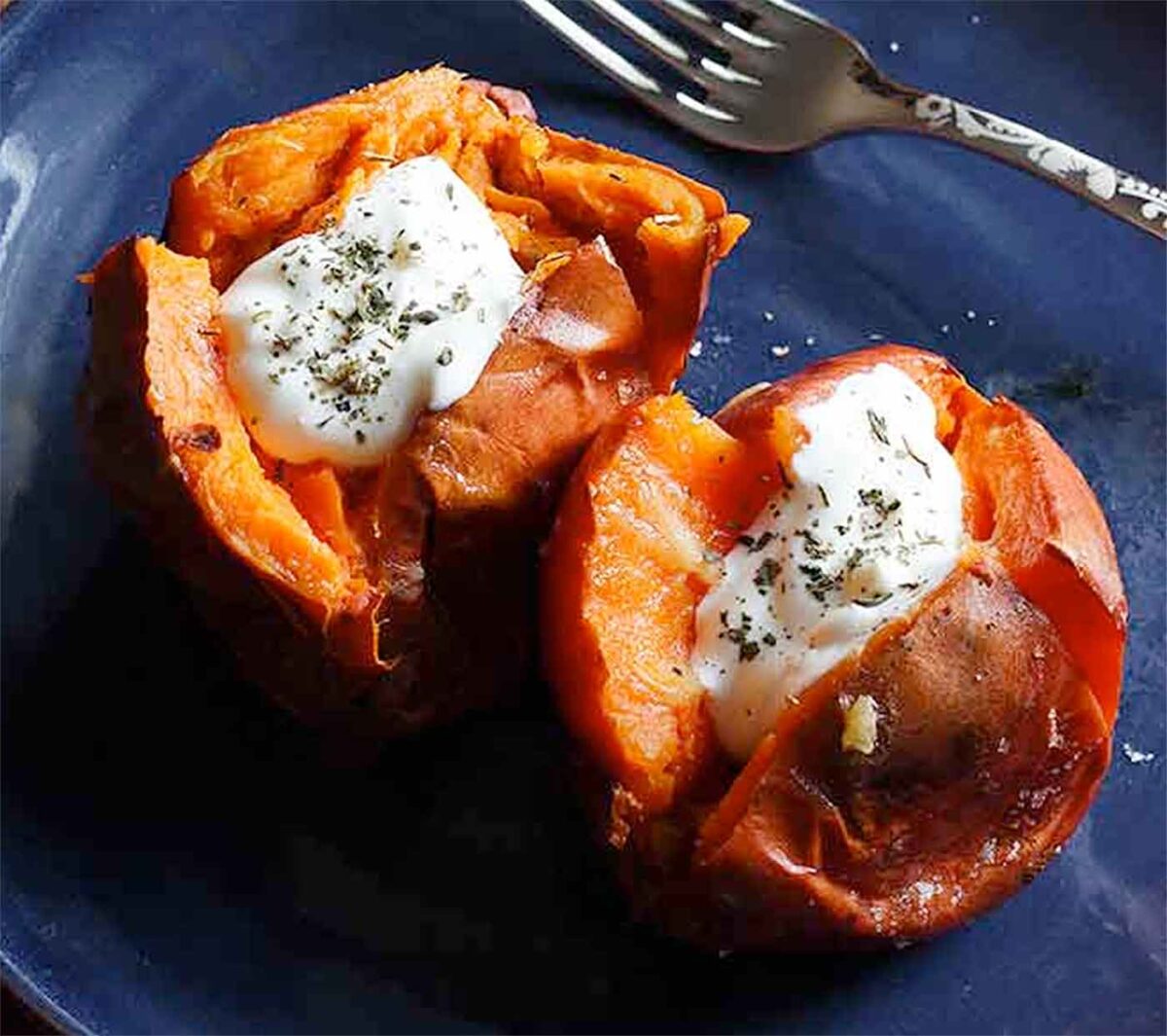 A Salt-Roasted Sweet Potato sliced in half and stuffed with herbed sour cream.