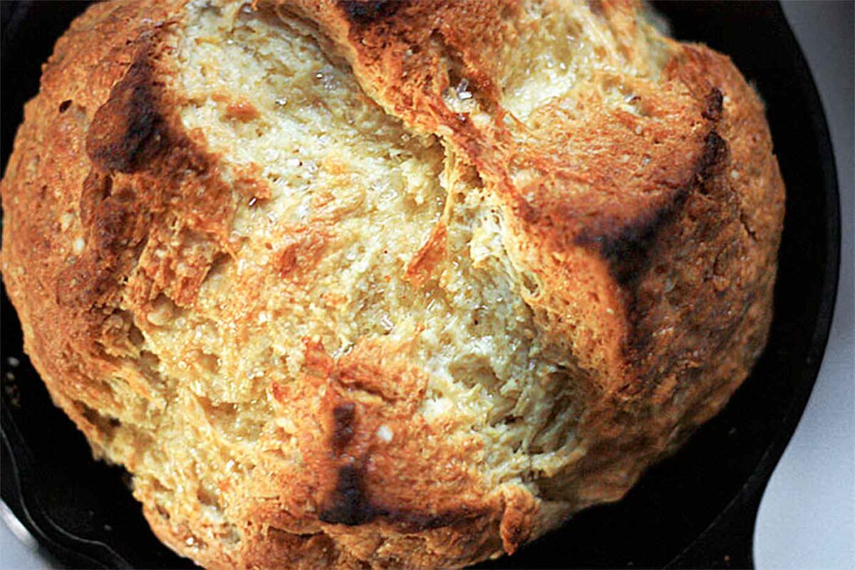 Close-up view of a loaf of Traditional Irish Soda Bread, baked in a cast iron skillet.