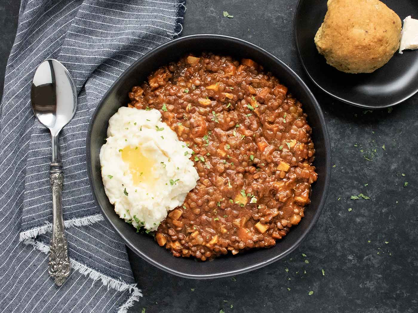 Vegetarian Irish Stew in a black bowl with mashed potatoes.