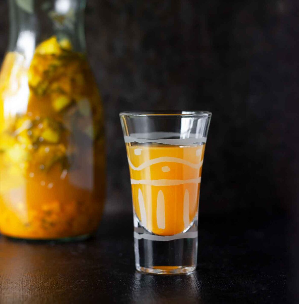 Fire Cider in a short glass and in a bottle.