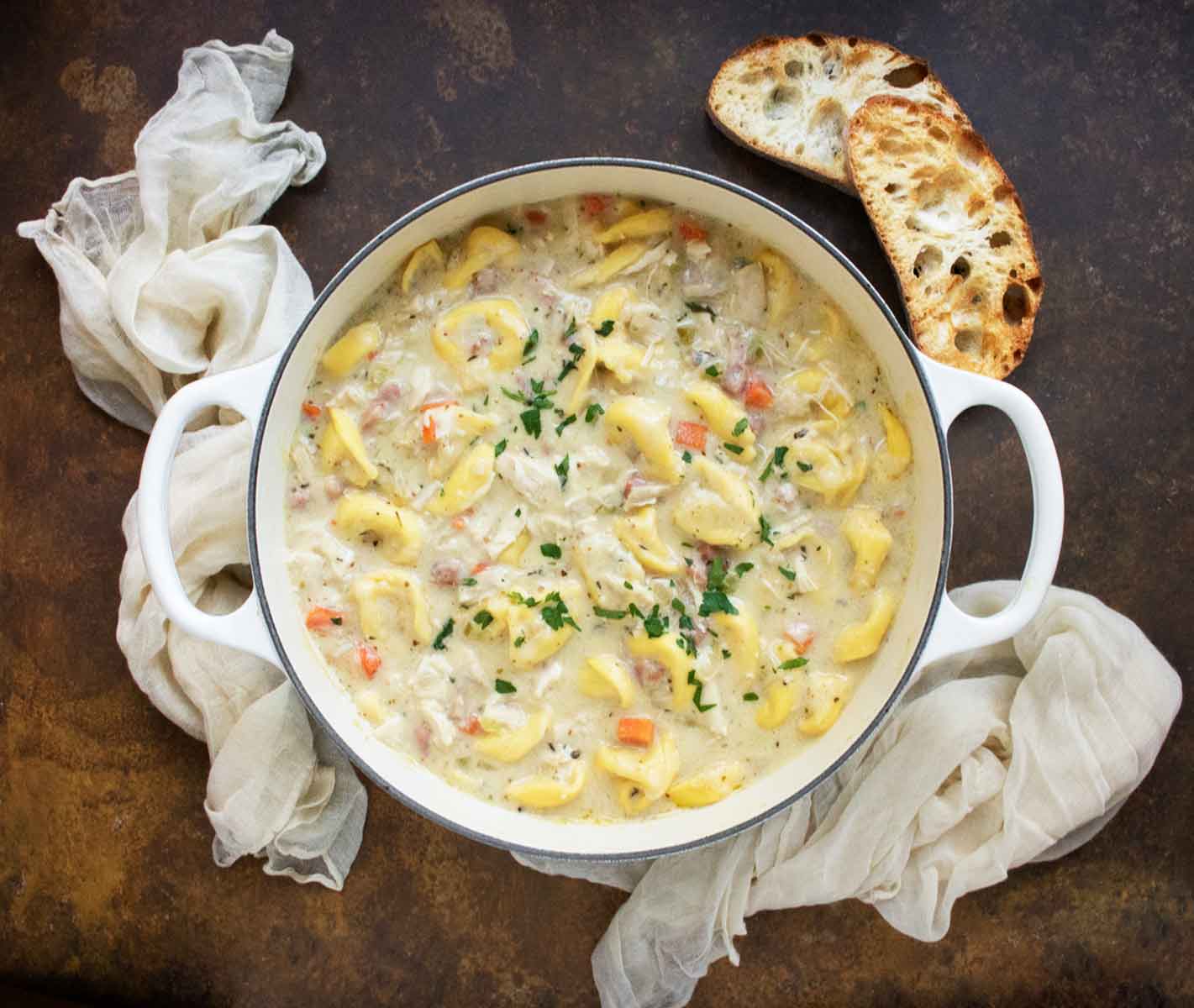 Overhead view of Cordon Bleu Tortellini Soup in a large white Dutch Oven