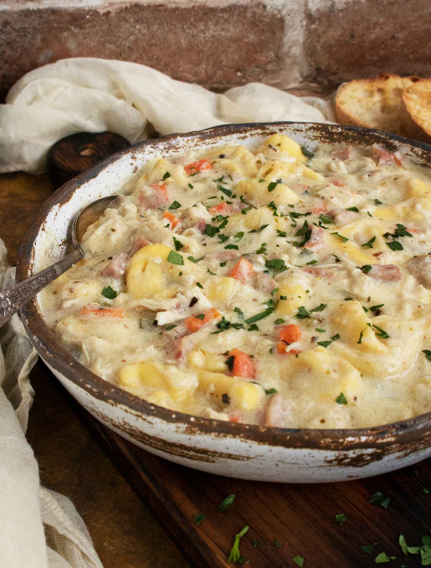 Side view of a bowl of Cordon Bleu Tortellini Soup.