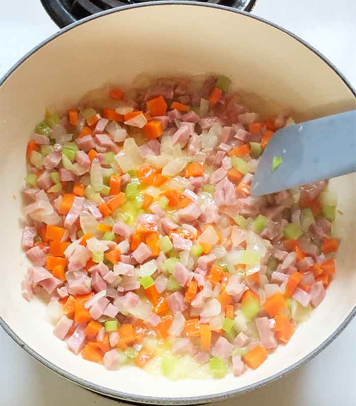 Sauteeing the ham and mirepoix in the pot.