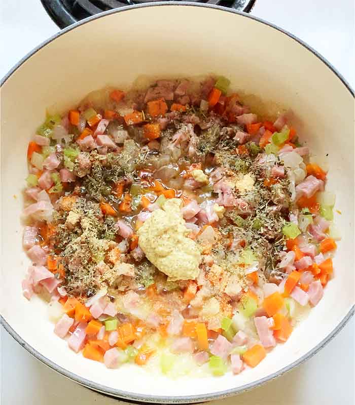 Adding the seasonings to the softened mirepoix.