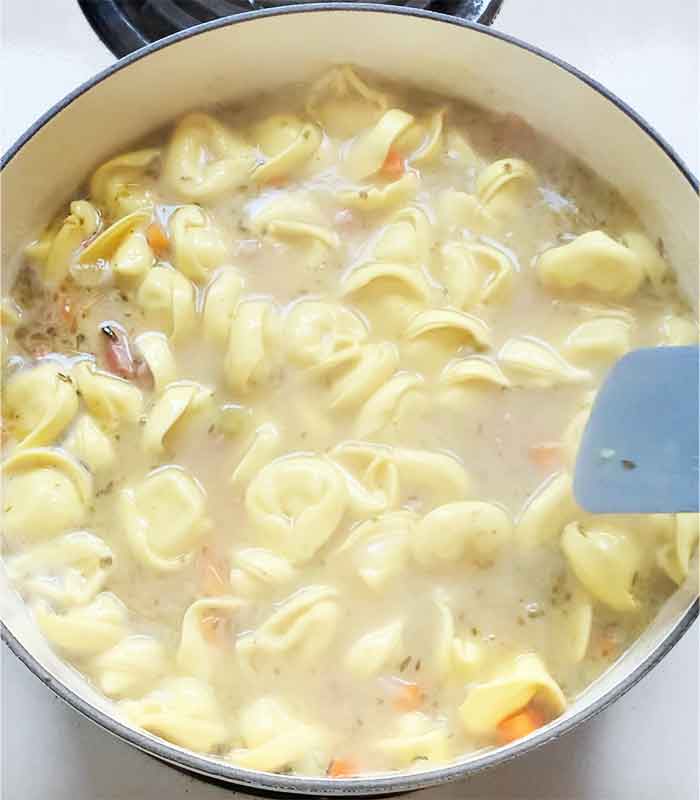 Cooking the tortellin in the soup.