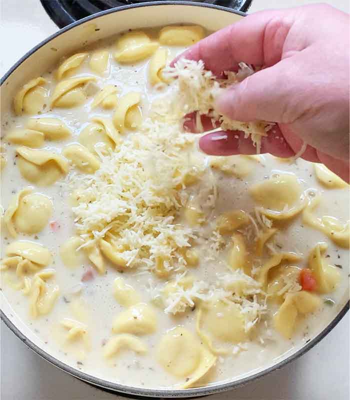 Adding the dairy and cheese to create the creamy broth.