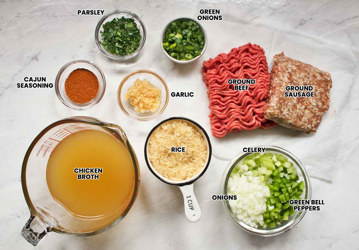 Ingredients for Easy Dirty Rice, measured out and arranged on a white marble board, labeled with text overlays.