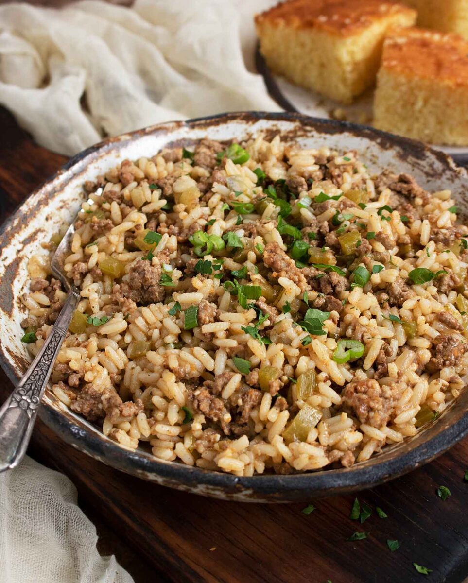 Side-angled view of a bowl of Easy Dirty Rice with a fork.