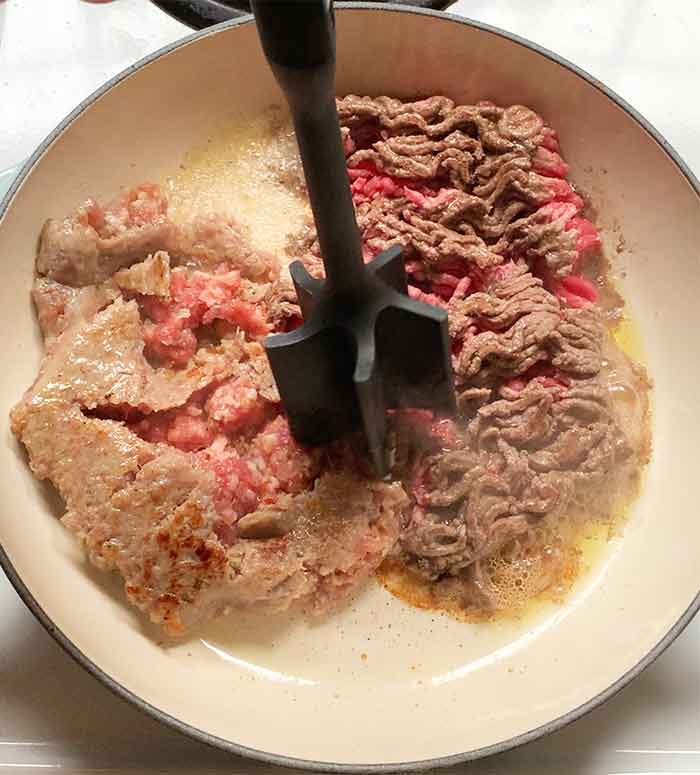 Browning and breaking up the chunks of meat.