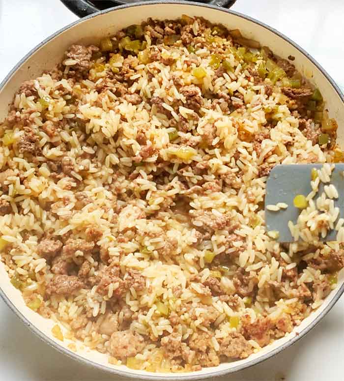 Stirring the dirty rice after cooking.