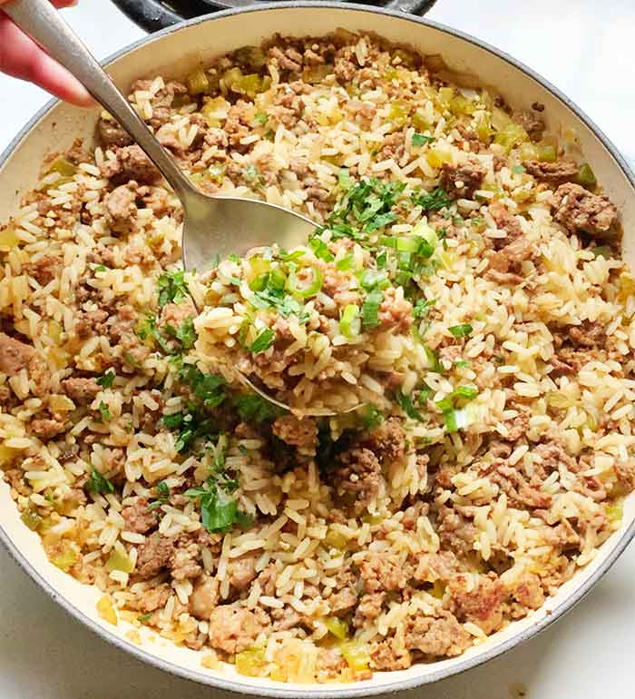 Close-up of a serving spoon filled with dirty rice.