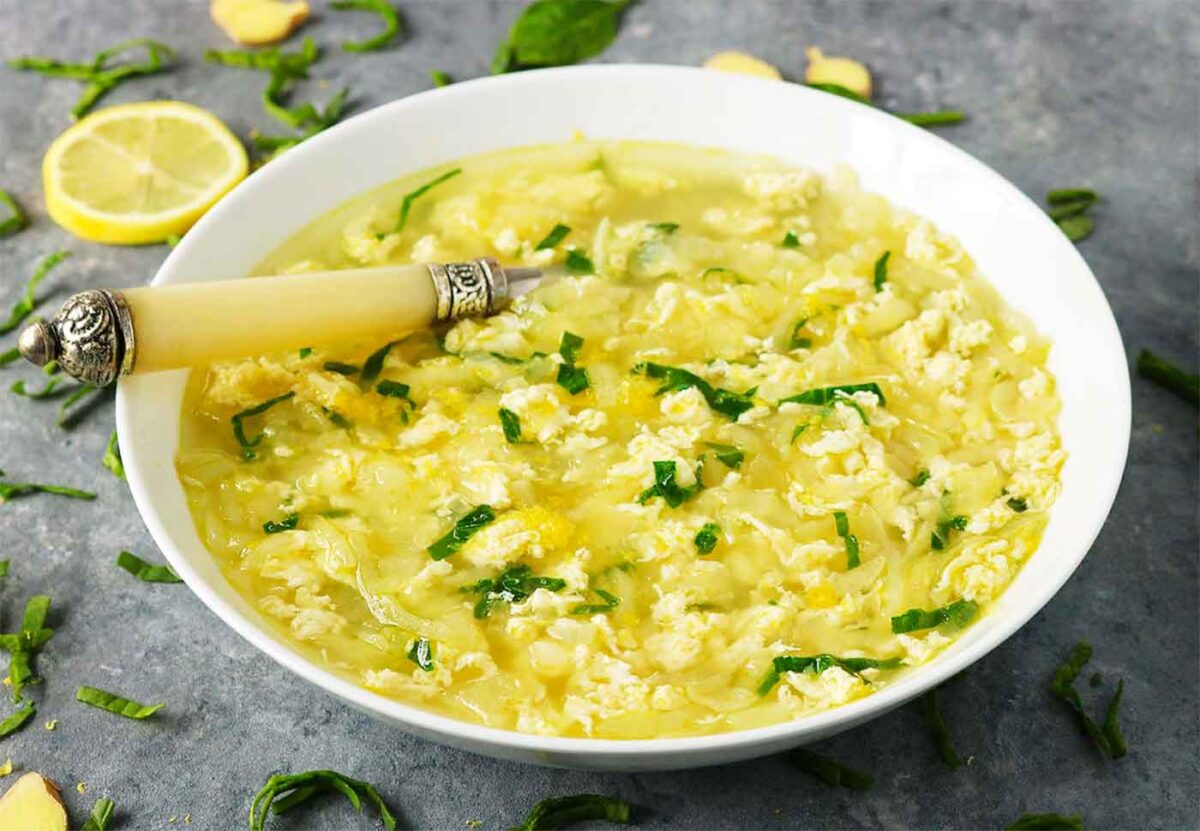 Side-angled view of Shredded Egg Soup in a white bowl with a spoon.