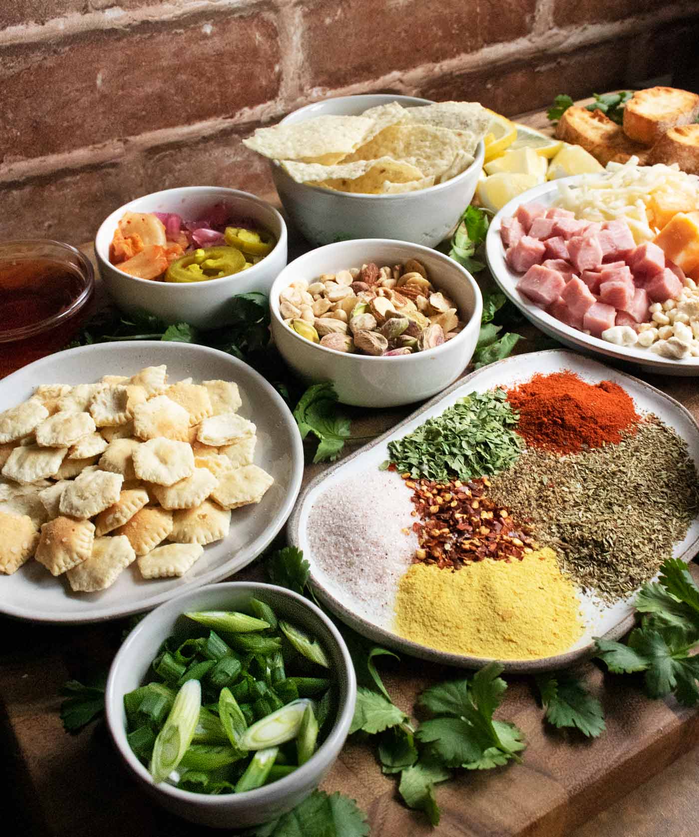 Angled view of a variety of soup toppings arranged on a wooden serving board.