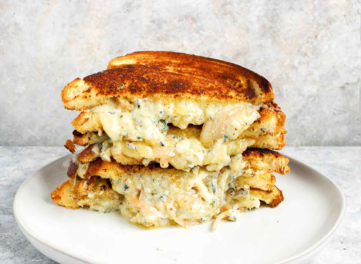 Side view of two stacked halves of a grilled cheese sandwich.