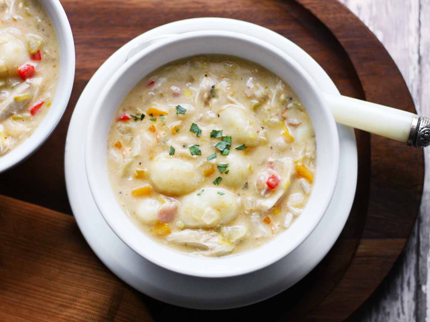 Overhead view of a bowl of Chicken Gnocchi Soup on a plate.