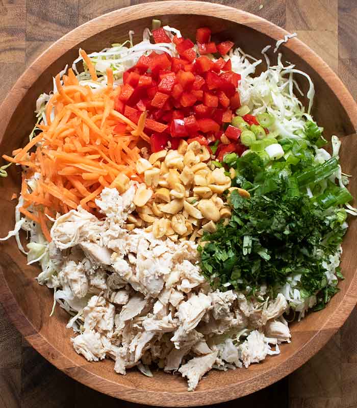 The salad ingredients arranged separately in a wooden salad bowl.