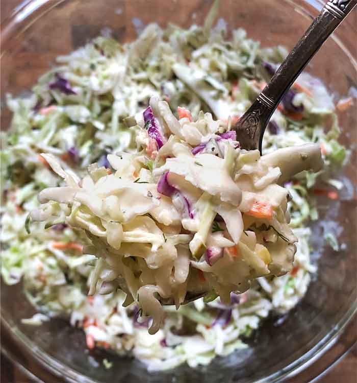 Closeup of a spoonful of the slaw with the bowl in the background.