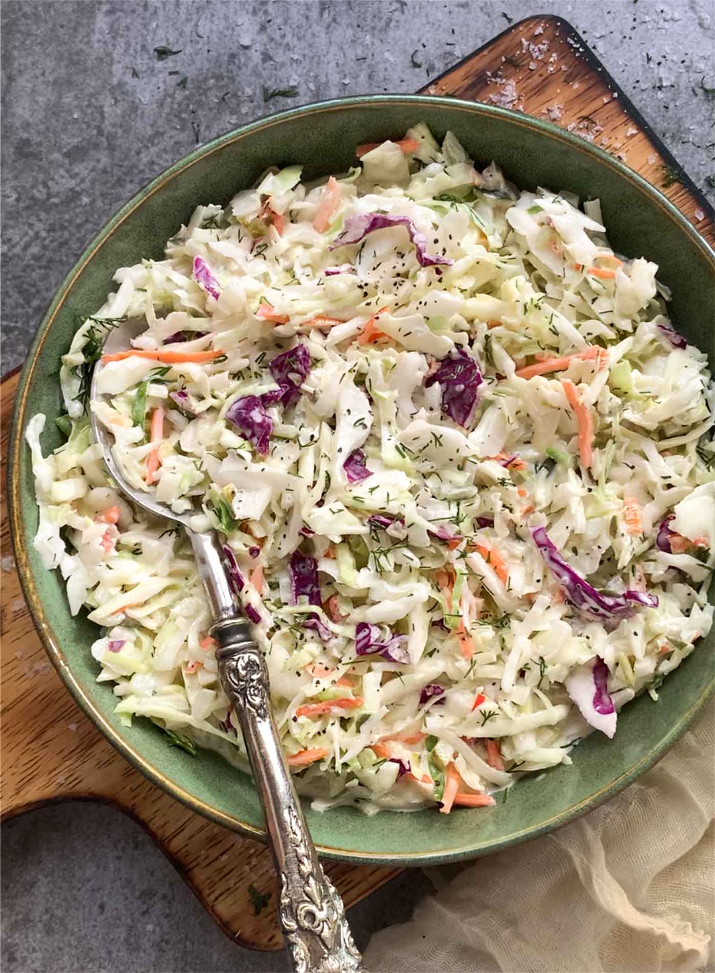 Overhead view of a bowl of Pickle de Gallo Coleslaw with a serving spoon.
