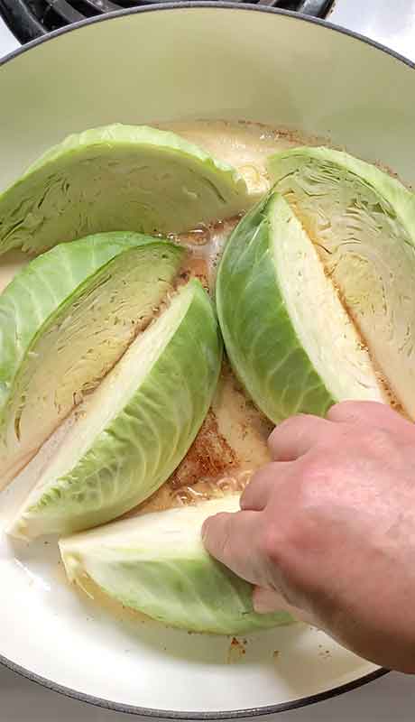 Arranging the cabbage wedges in the braising pan.
