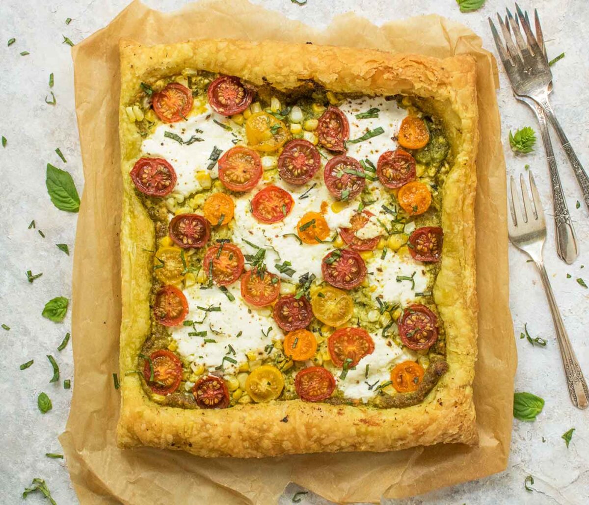 Puff Pastry Tomato Corn tart on a square of parchment paper.