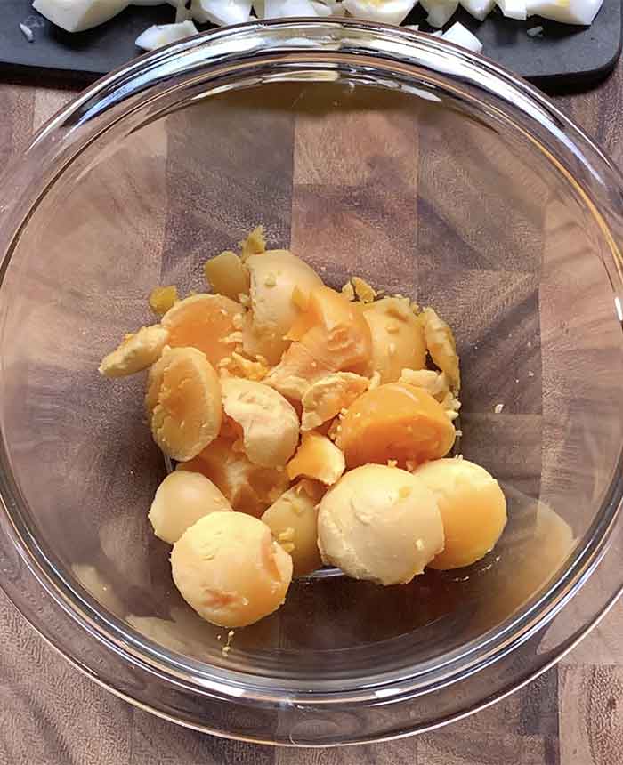 Cooked egg yolks in a small glass mixing bowl.