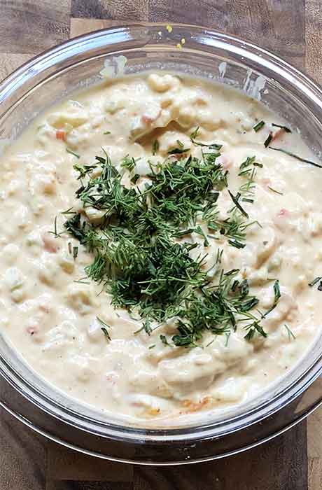 Finishing the dressing with some chopped fresh dill and chives.
