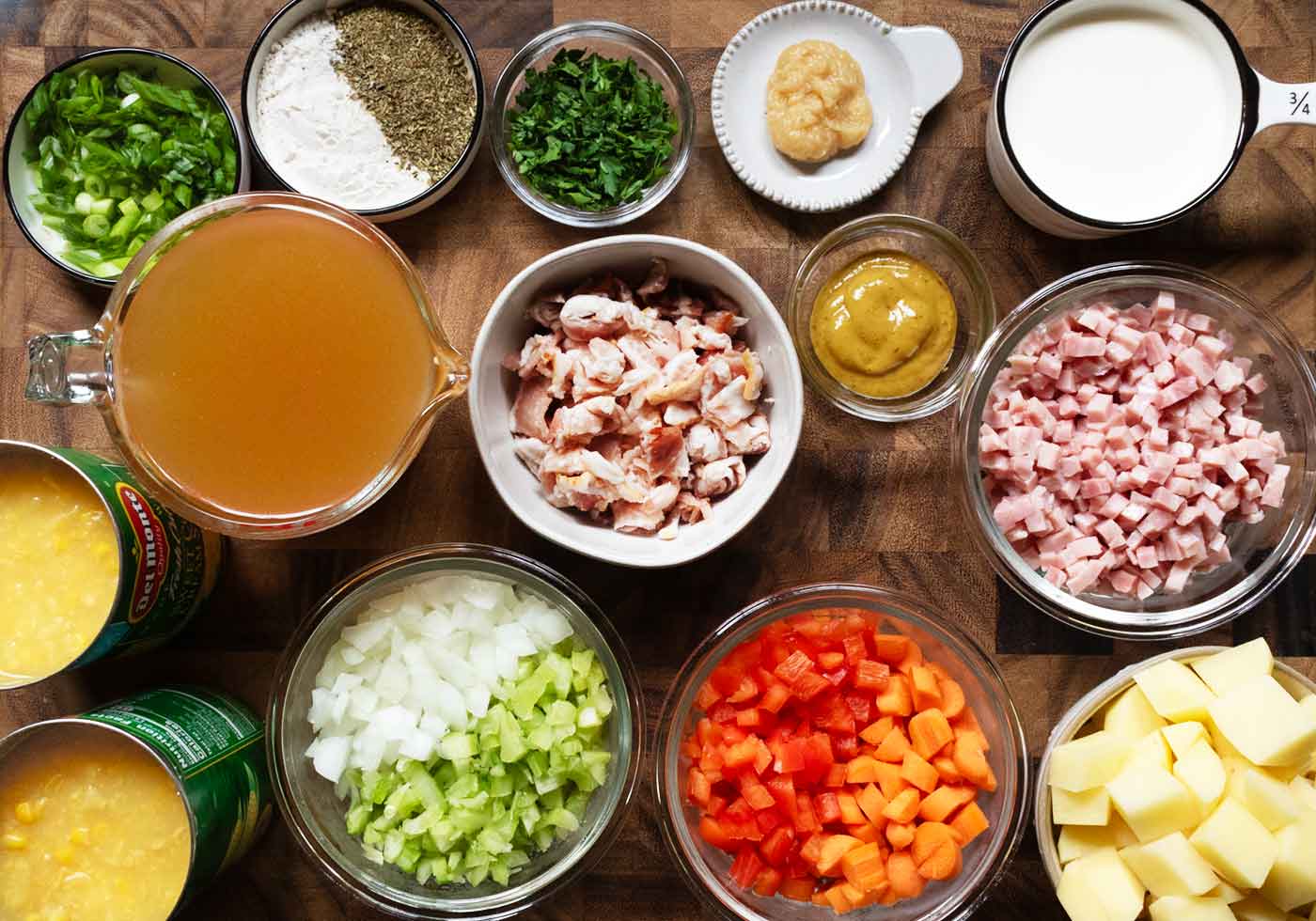 Ingredients for Ham and Corn Chowder measured out into containers and arranged on a wooden board.