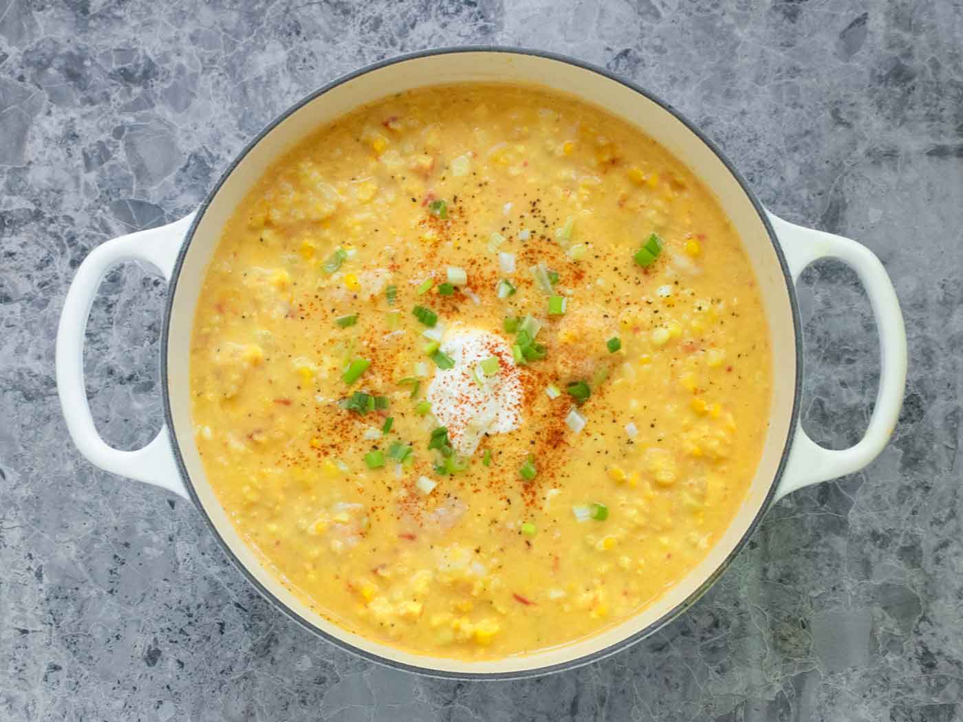 Overhead view of Shrimp & Corn Chowder in a large white Dutch oven.