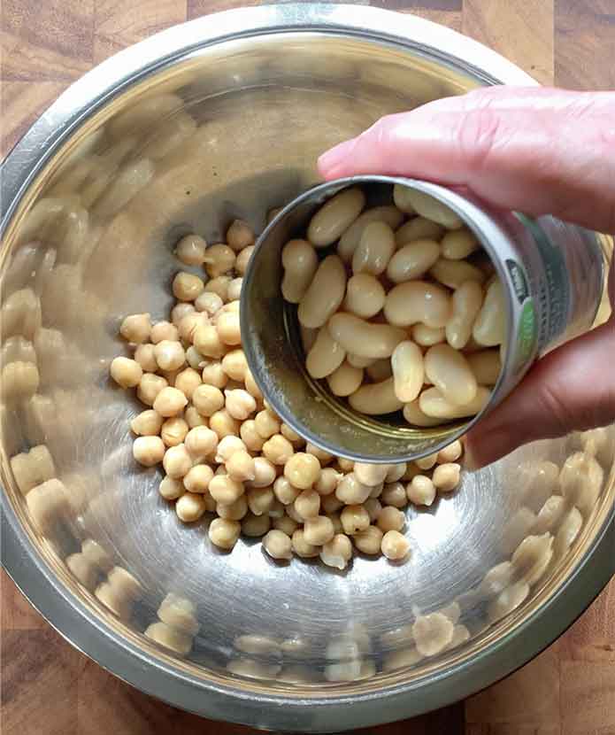 Adding beans to the mixing bowl.