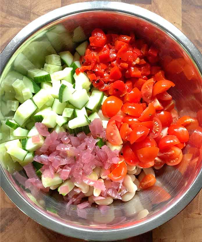 Chopping vegetables arranged in the bowl, on top of the beans.