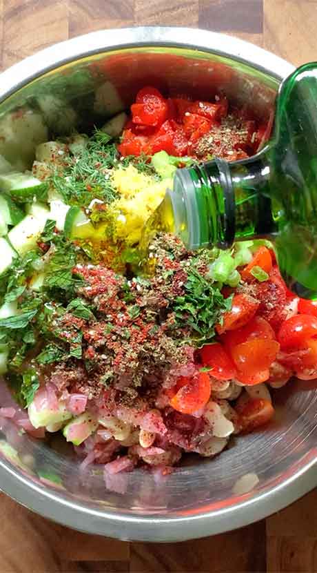 Dressing the salad with extra virgin olive oil.