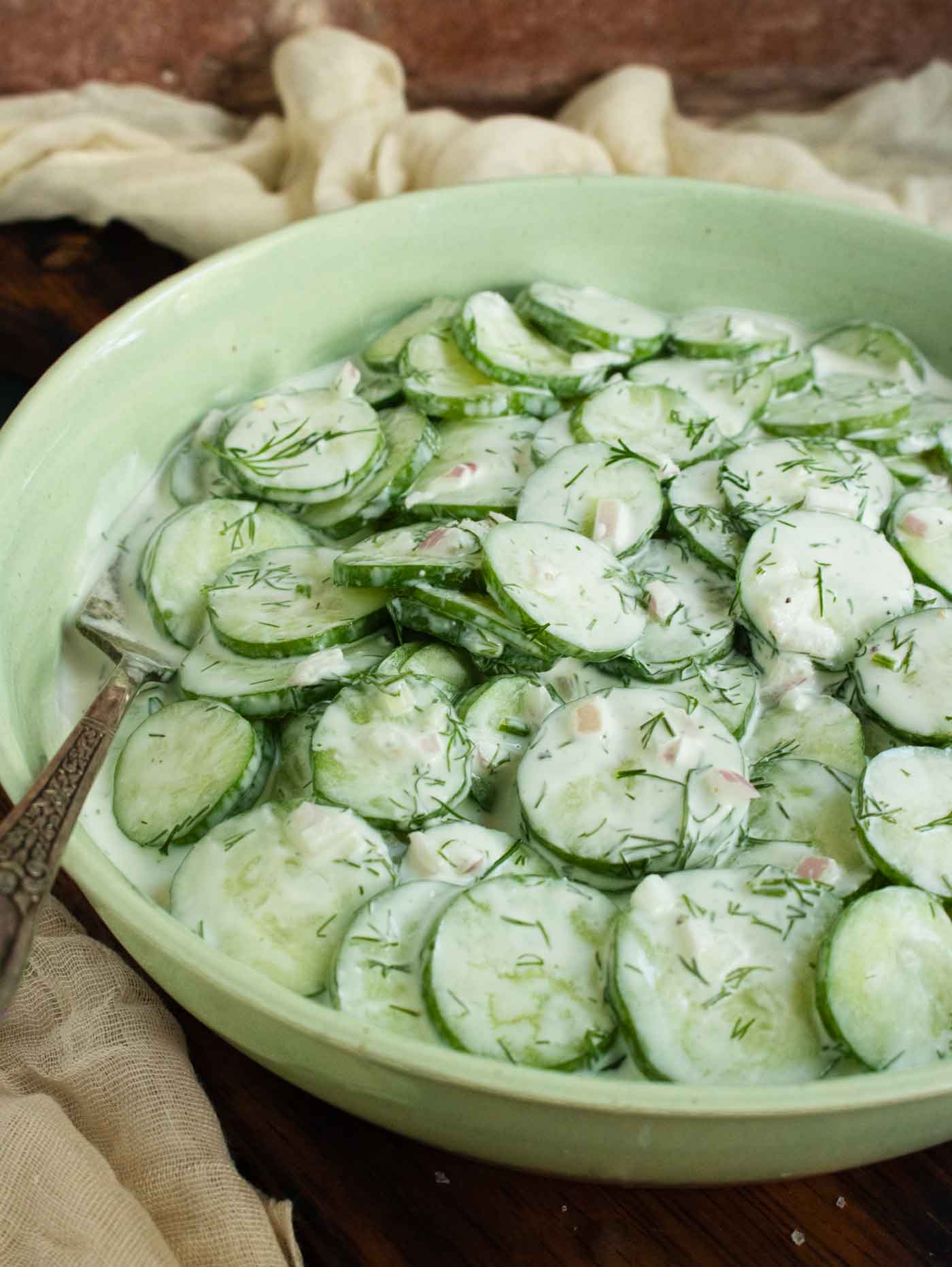 Side-angled view of a bowl of cucumber salad.