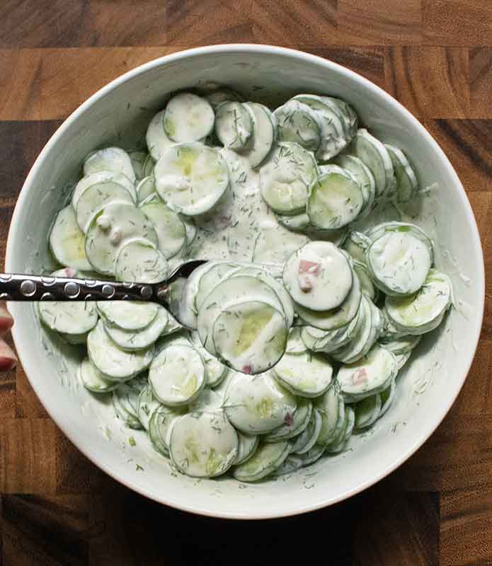 The finished salad with a fork holding a few cucumber slices.