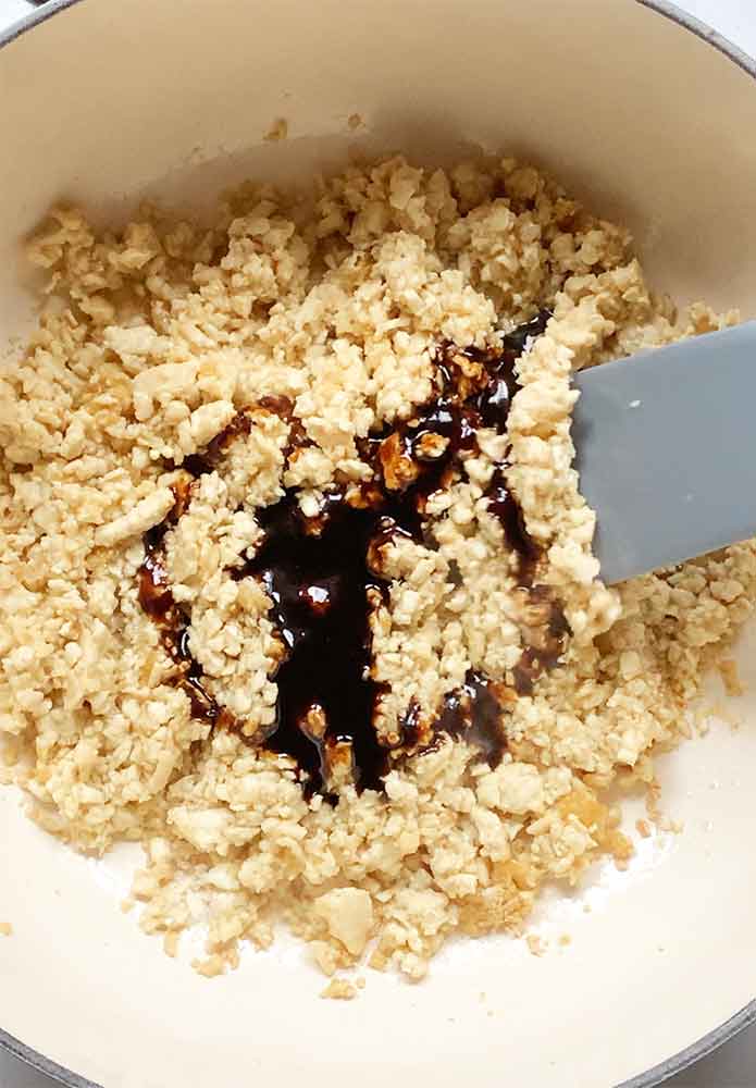 Stirring the Thai BBQ sauce into the cooked tofu shreds.