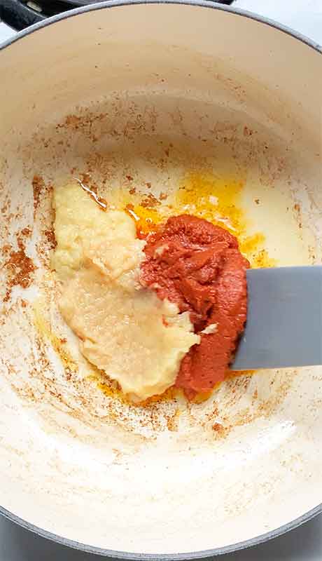 Cooking the garlic, Thai red curry paste, and ginger in the soup pot.