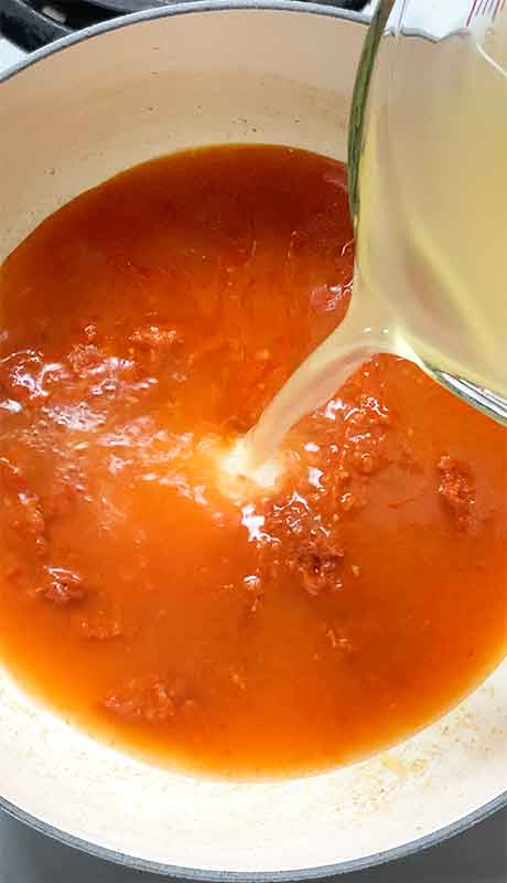 Pouring the liquids into the soup pot.